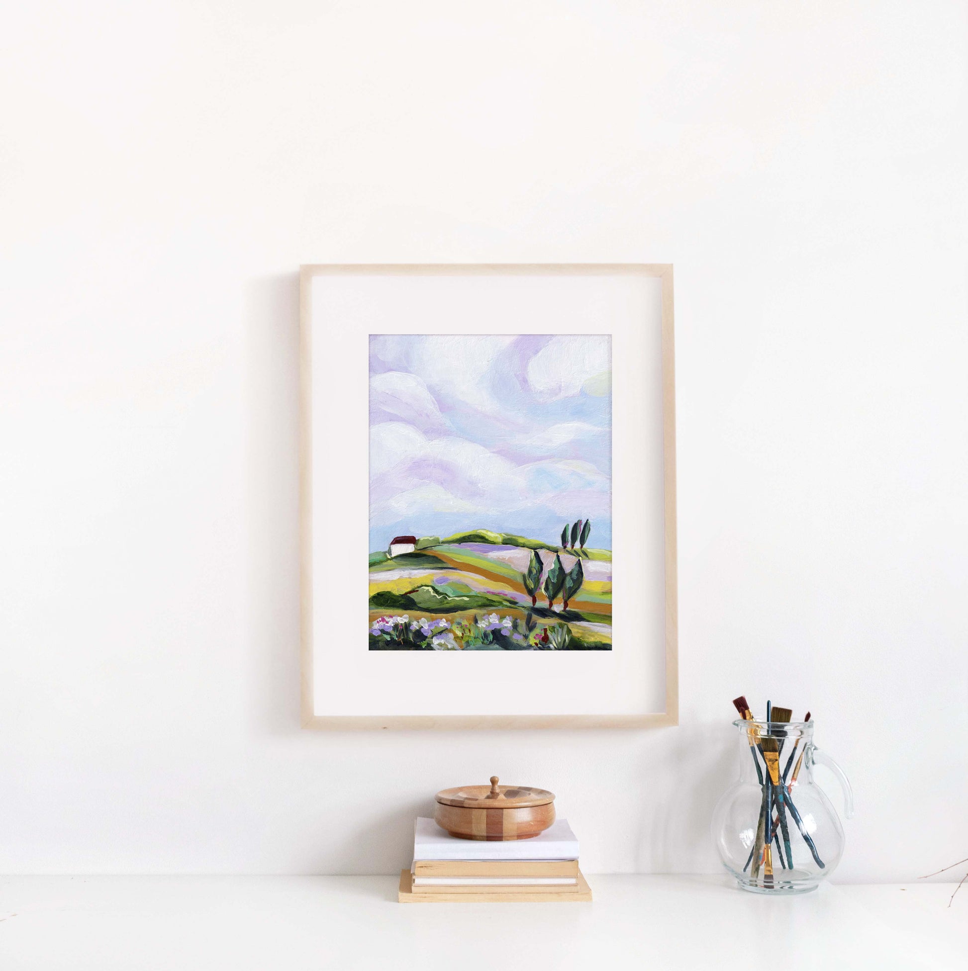 Framed artwork of a landscape with a white wall background