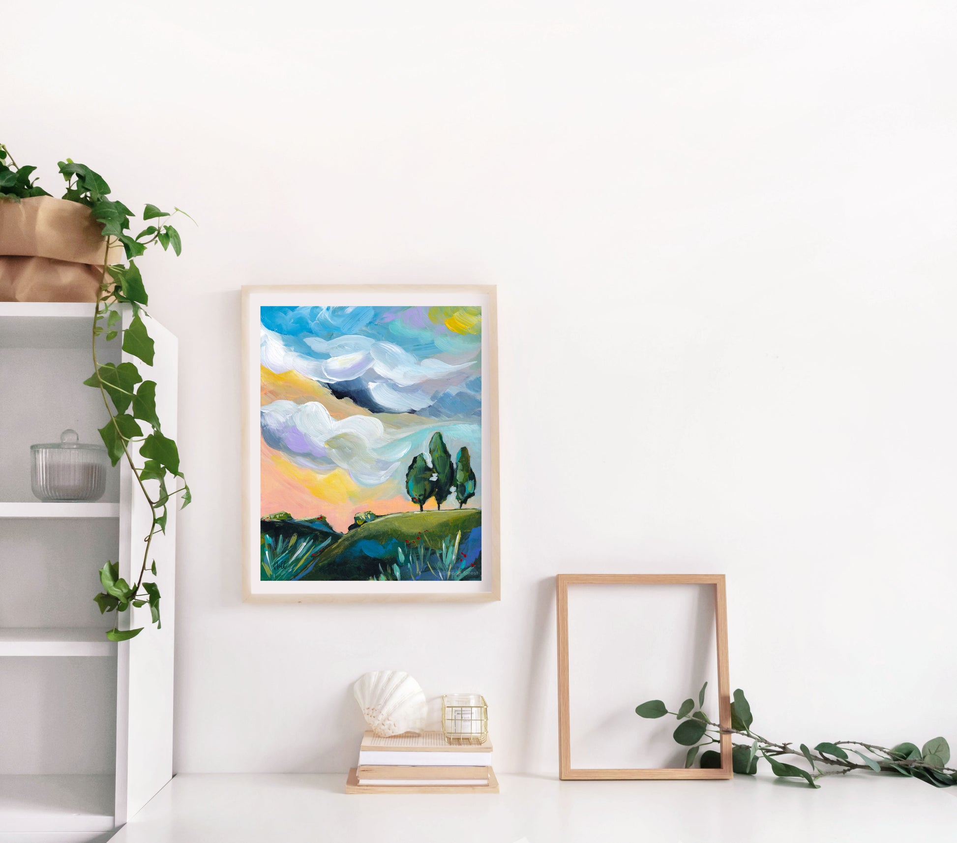 Framed abstract landscape art on a white wall with minimal decor