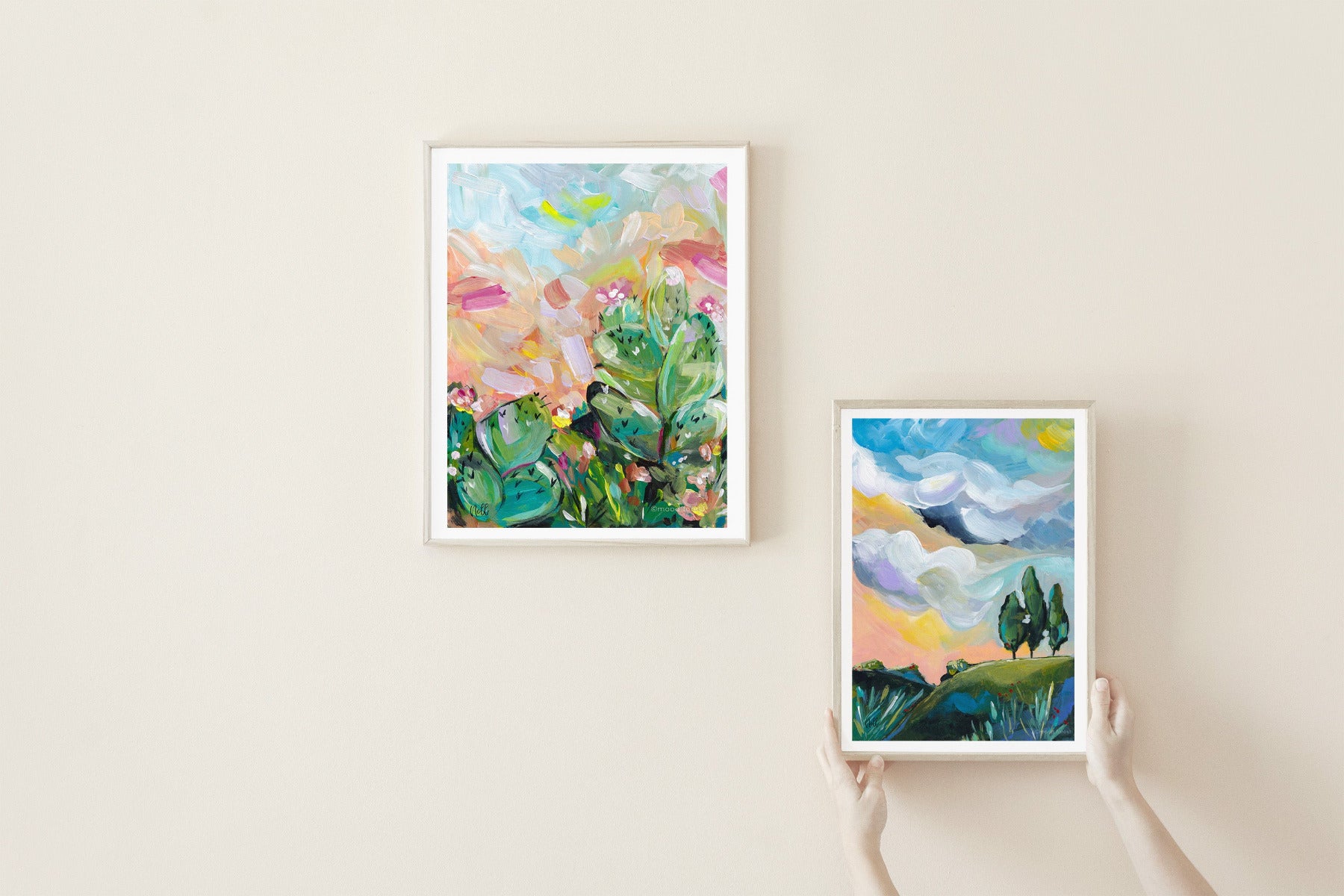 Two framed artworks on a beige wall, one floral and one landscape.