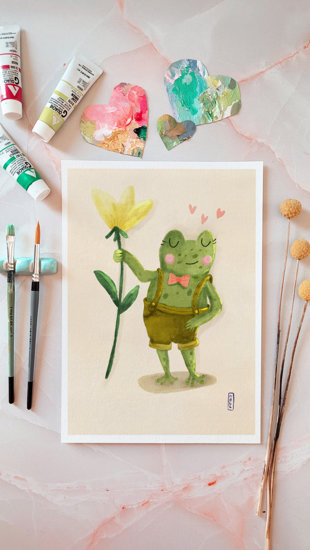 Illustration of a frog holding a flower with paint tubes and brushes on a pink background