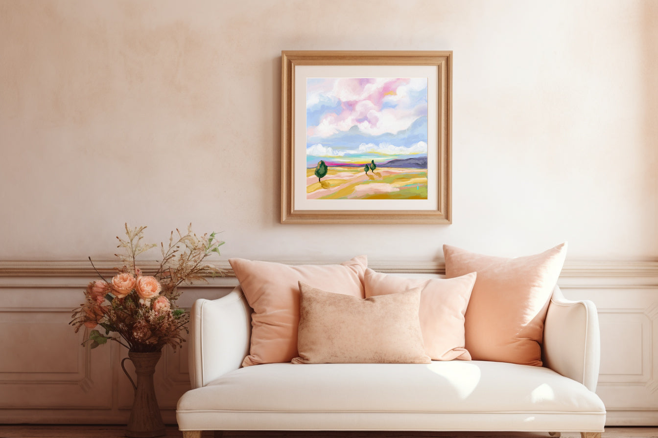Living room with a white sofa, pink pillows, and a framed landscape painting on the wall.