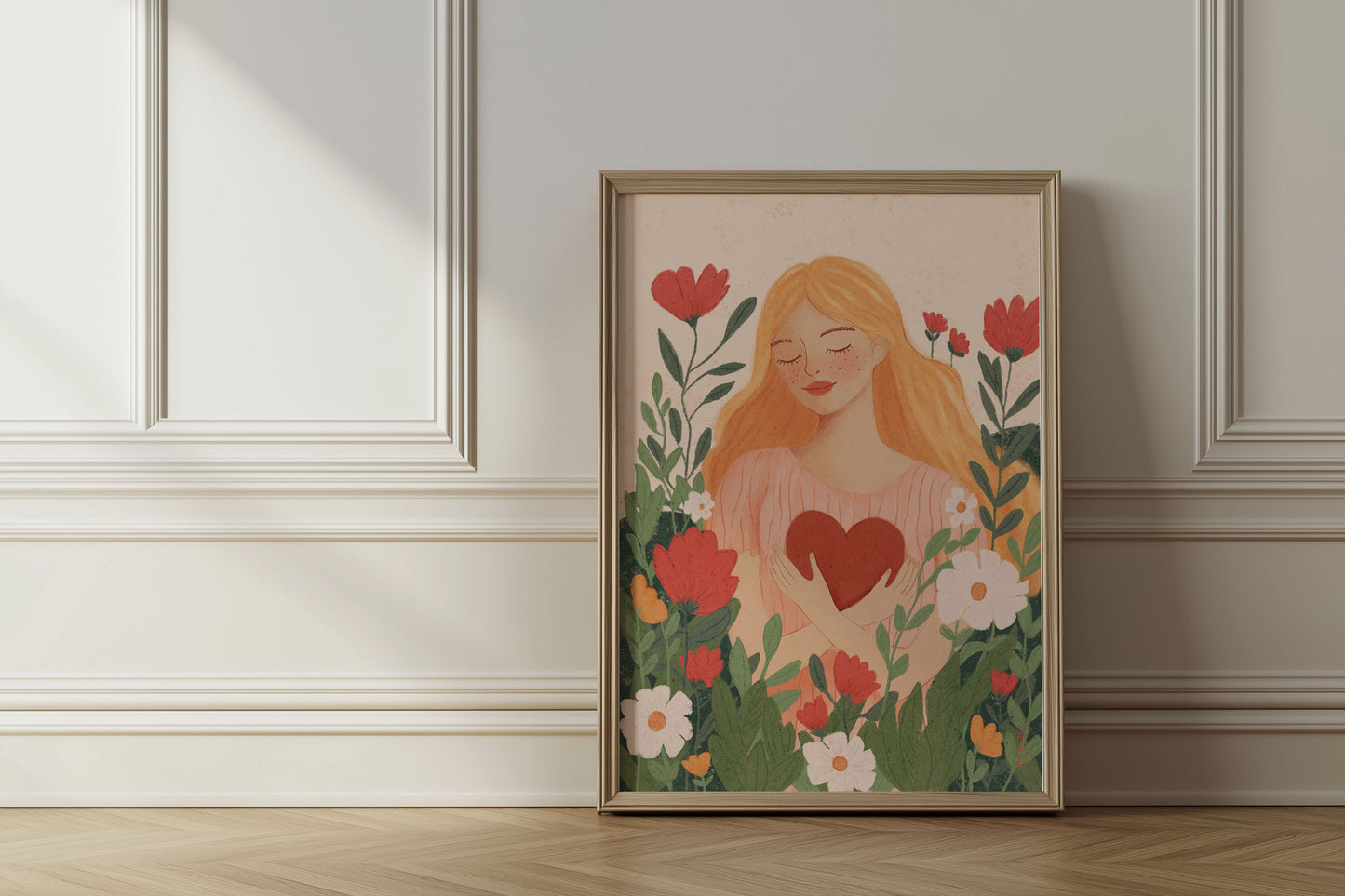 Framed artwork of a woman holding a heart surrounded by flowers on a wall.