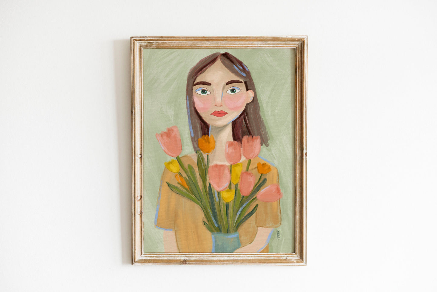 Framed artwork of a woman holding flowers on a white wall
