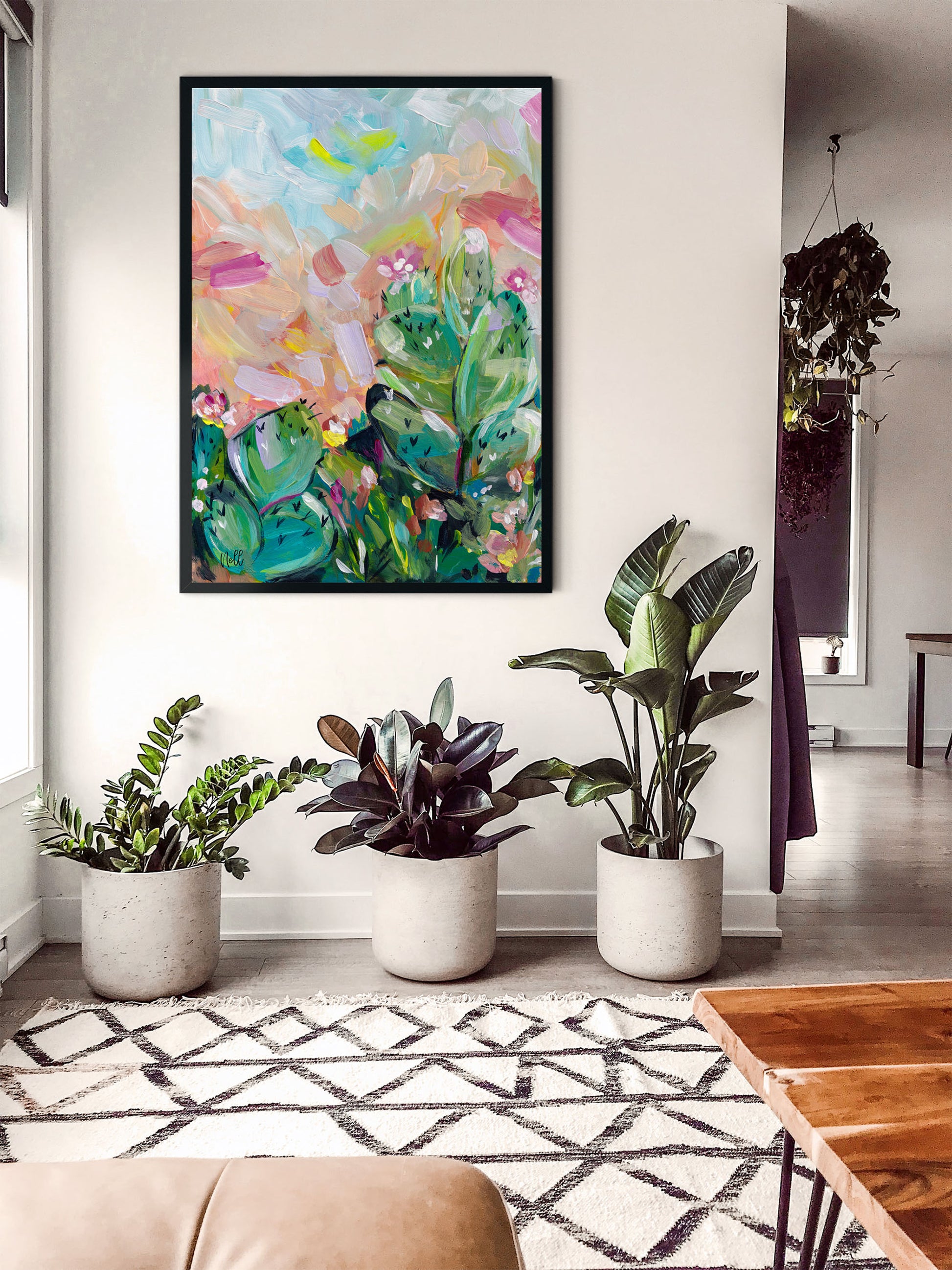 Living room with a colorful abstract painting on the wall, potted plants, and a patterned rug.