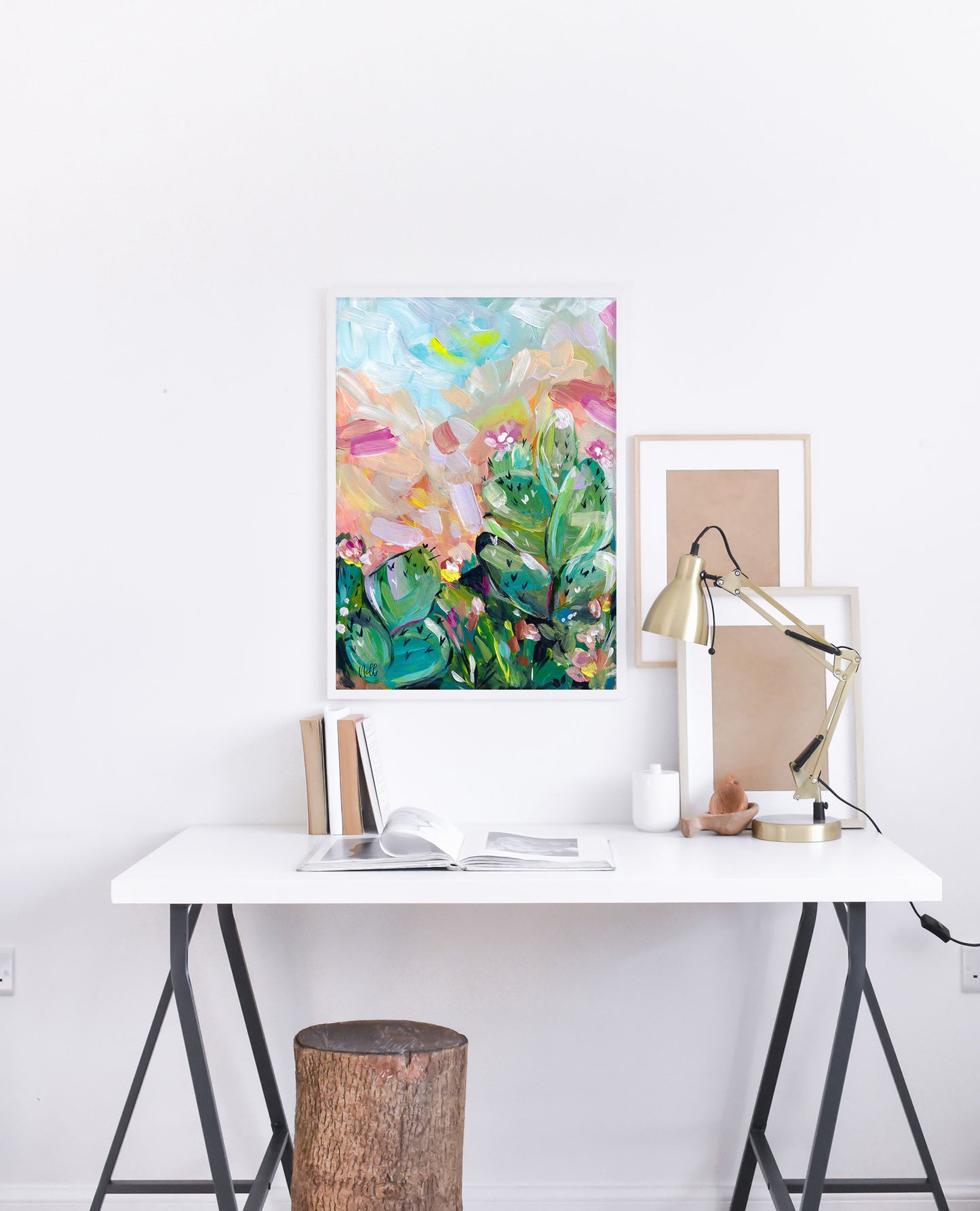 Modern office setup with a white desk, lamp, and colorful abstract art on a white wall.