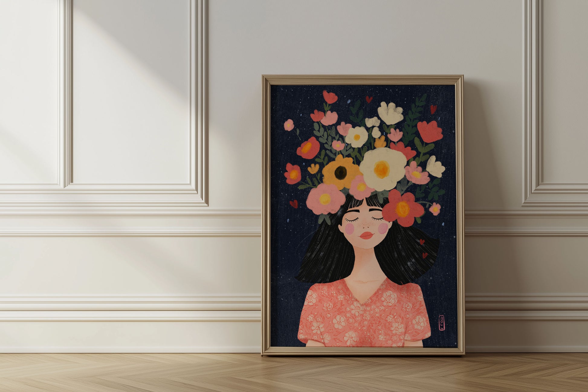 Framed artwork of a woman with flowers on her head in a room with light-colored walls and wooden floor.