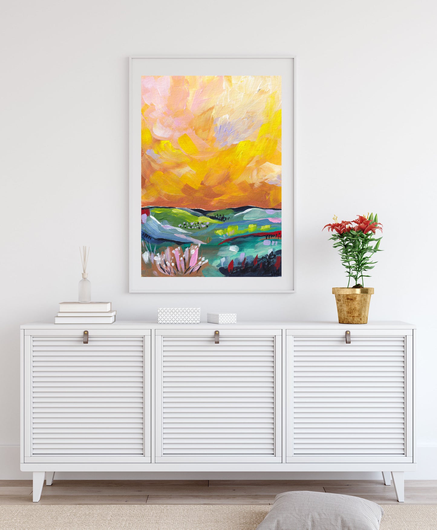 Colorful abstract painting on a white wall above a white cabinet.