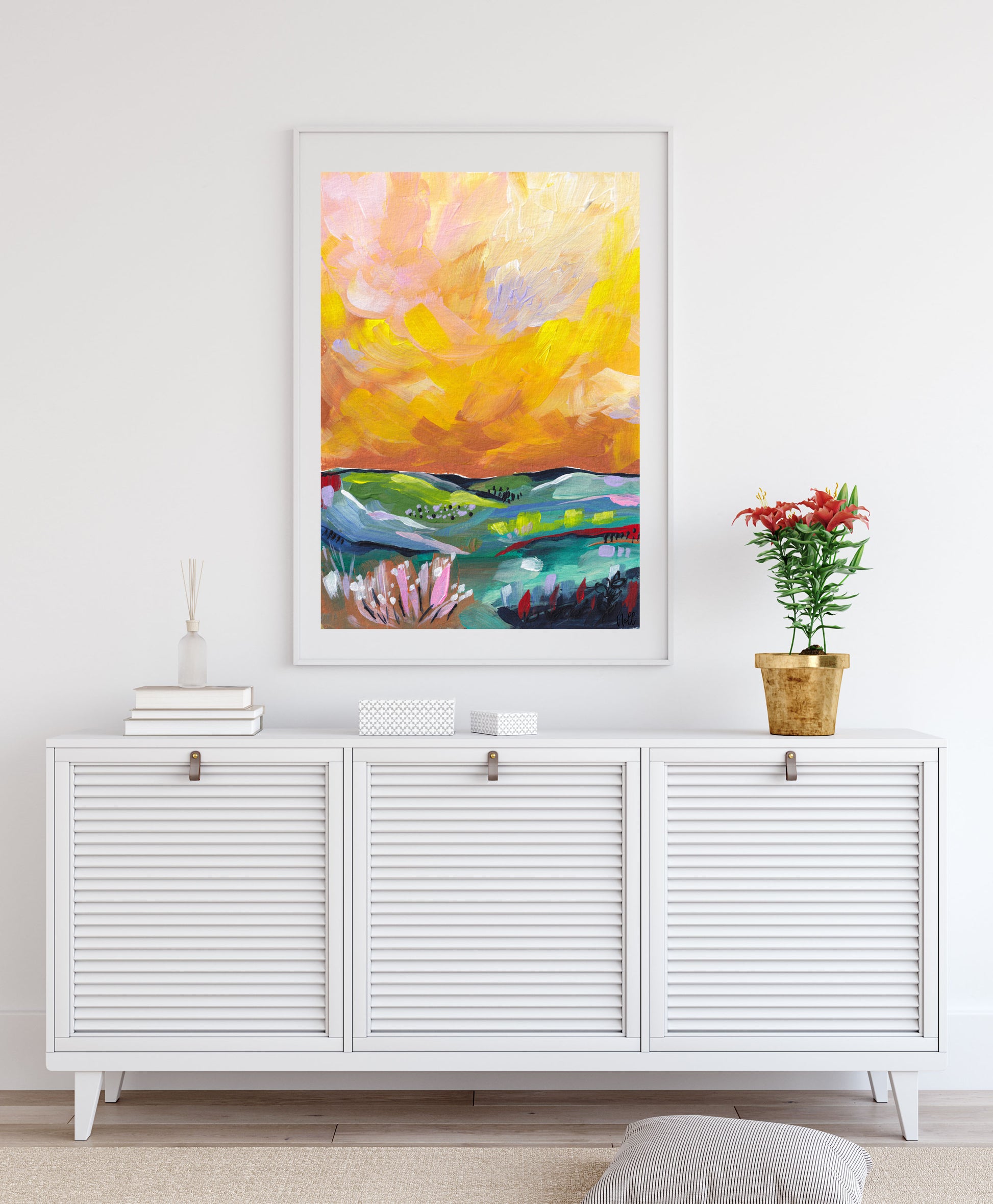 Colorful abstract painting on a white wall above a white cabinet.