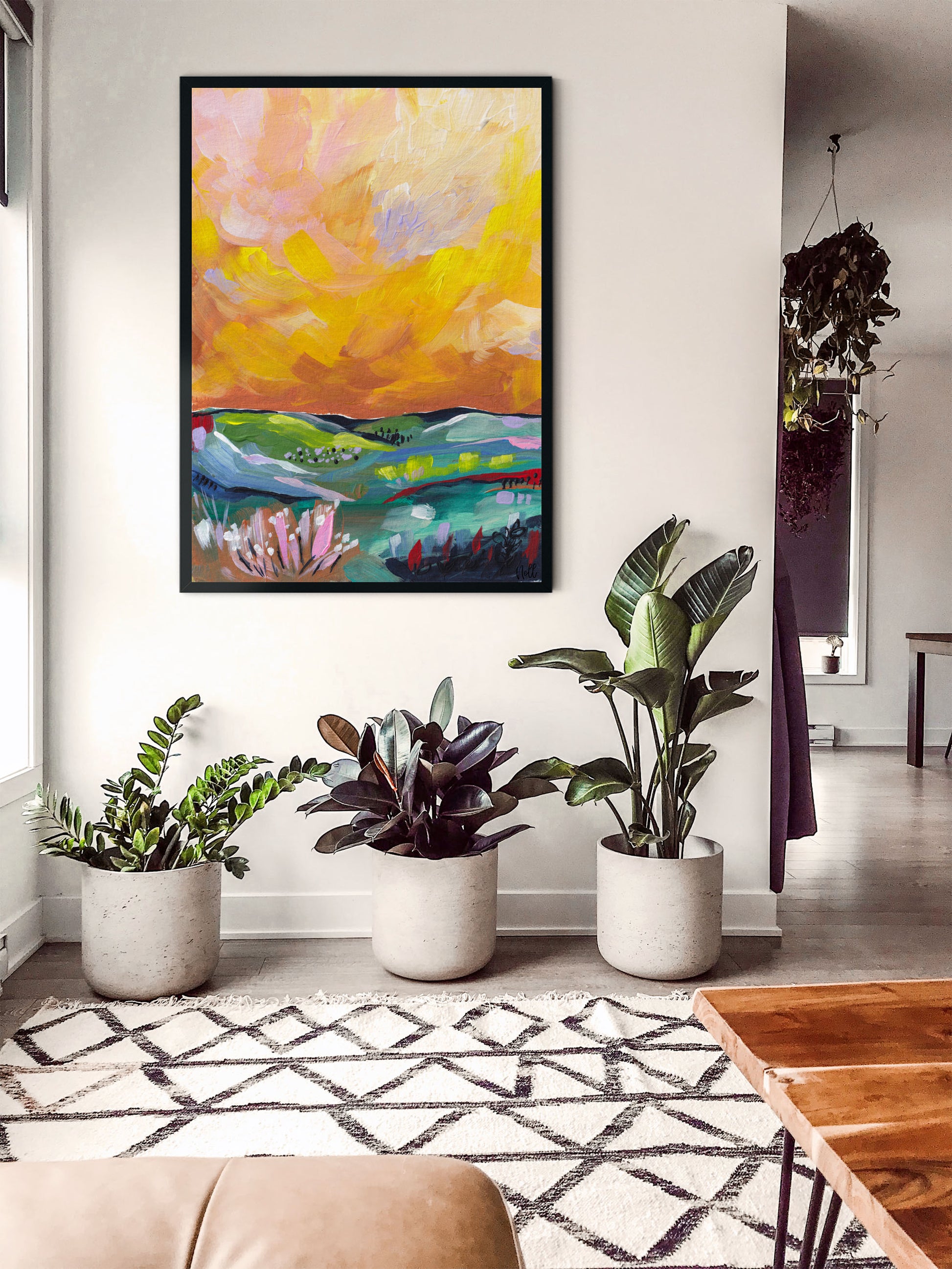 Colorful abstract painting on a wall with plants and a rug in the foreground