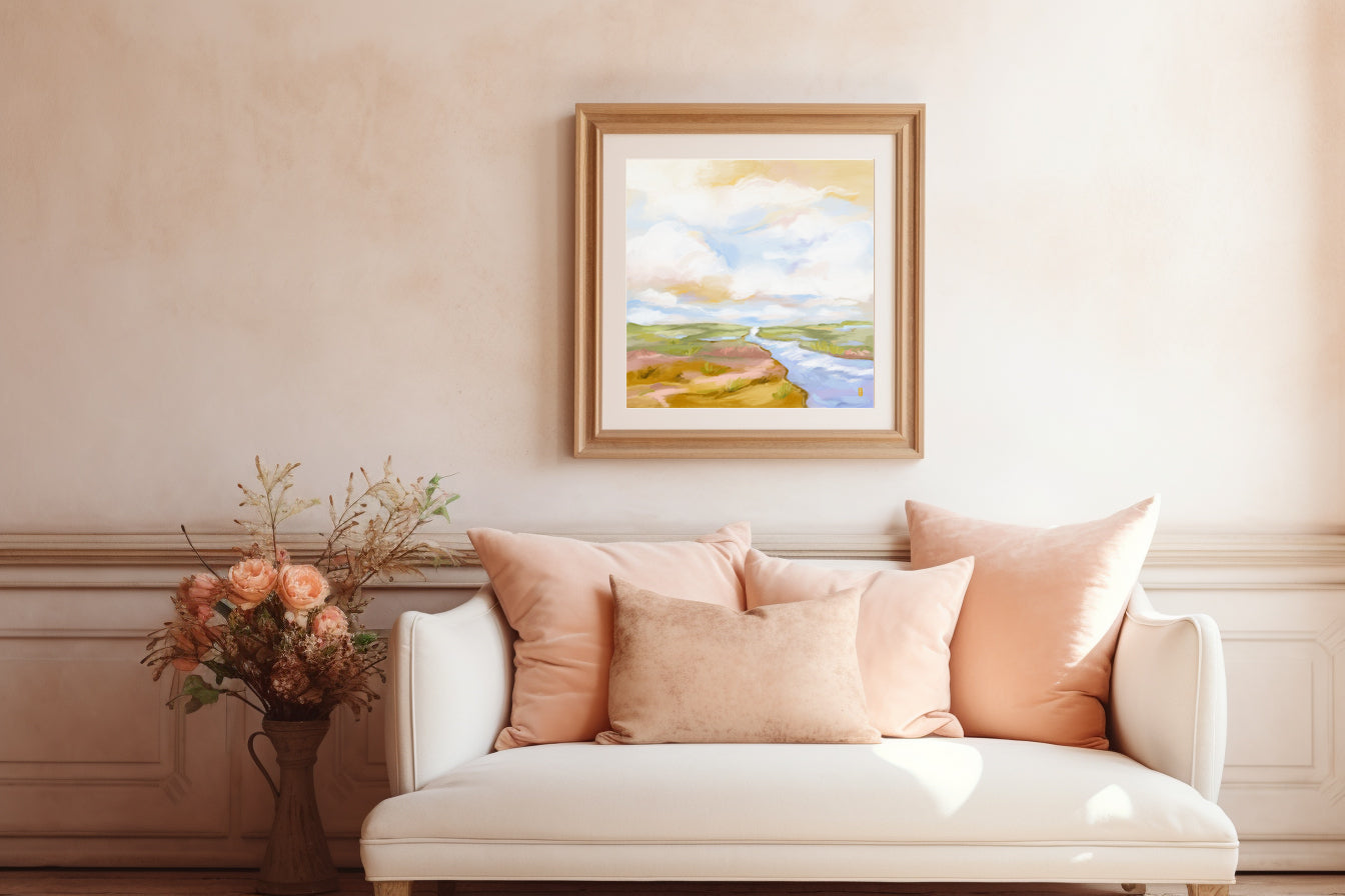 Living room with a white sofa, pink pillows, and a framed landscape painting on the wall.