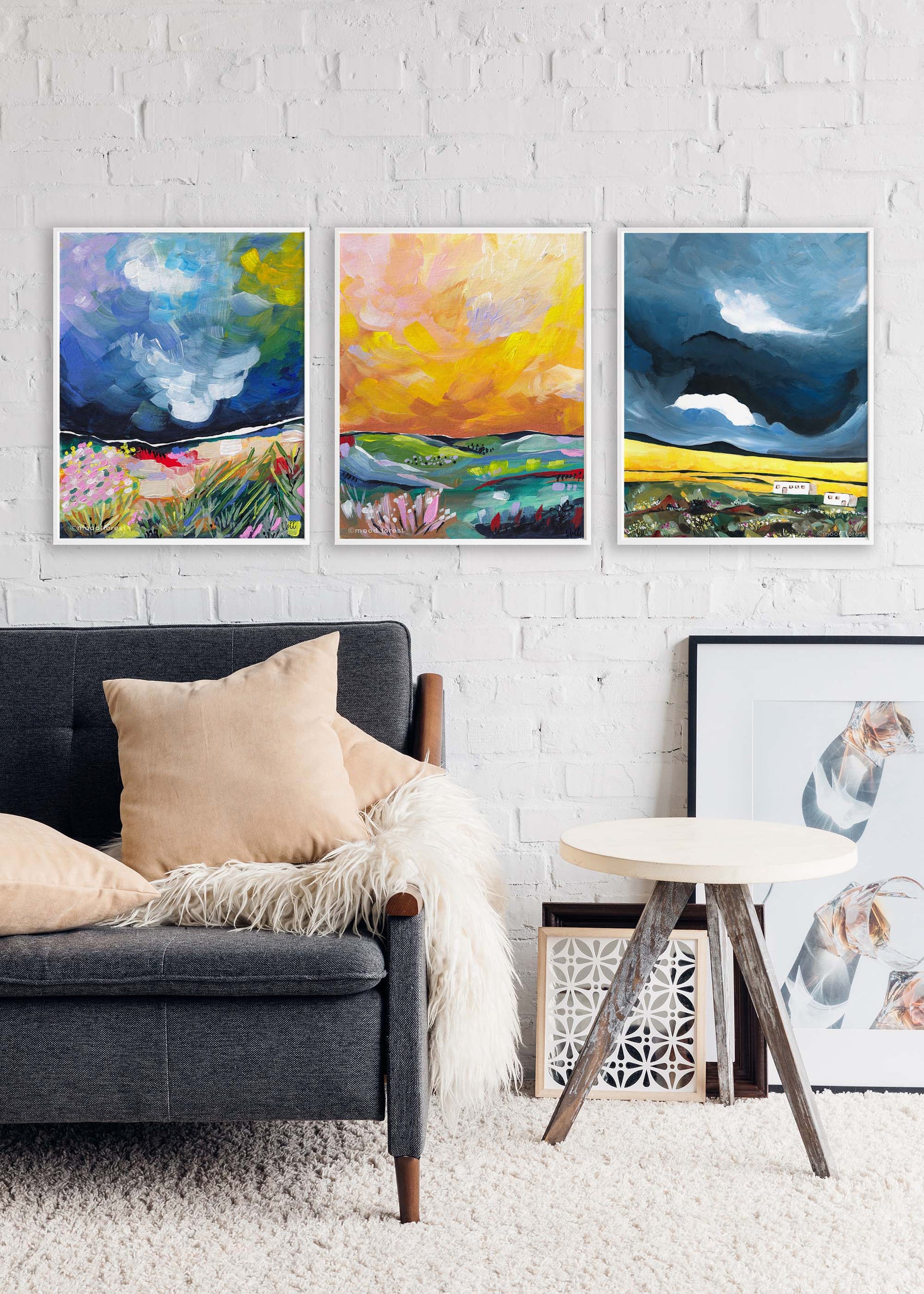 Living room with a gray sofa, colorful abstract paintings on the wall, and a small table.