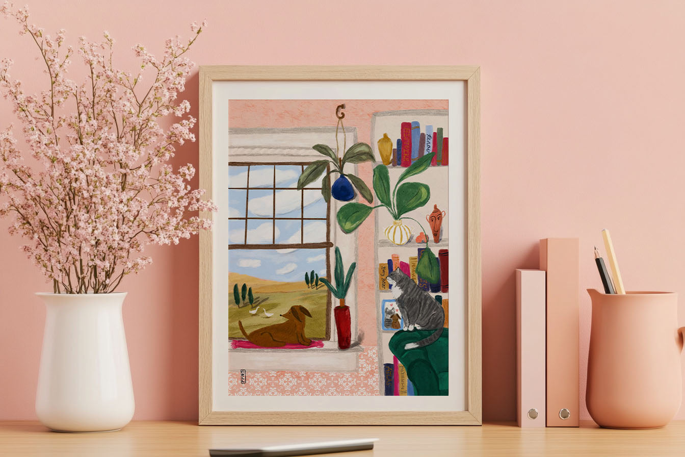 Framed artwork of a cat by a window on a pink wall with decorative items.
