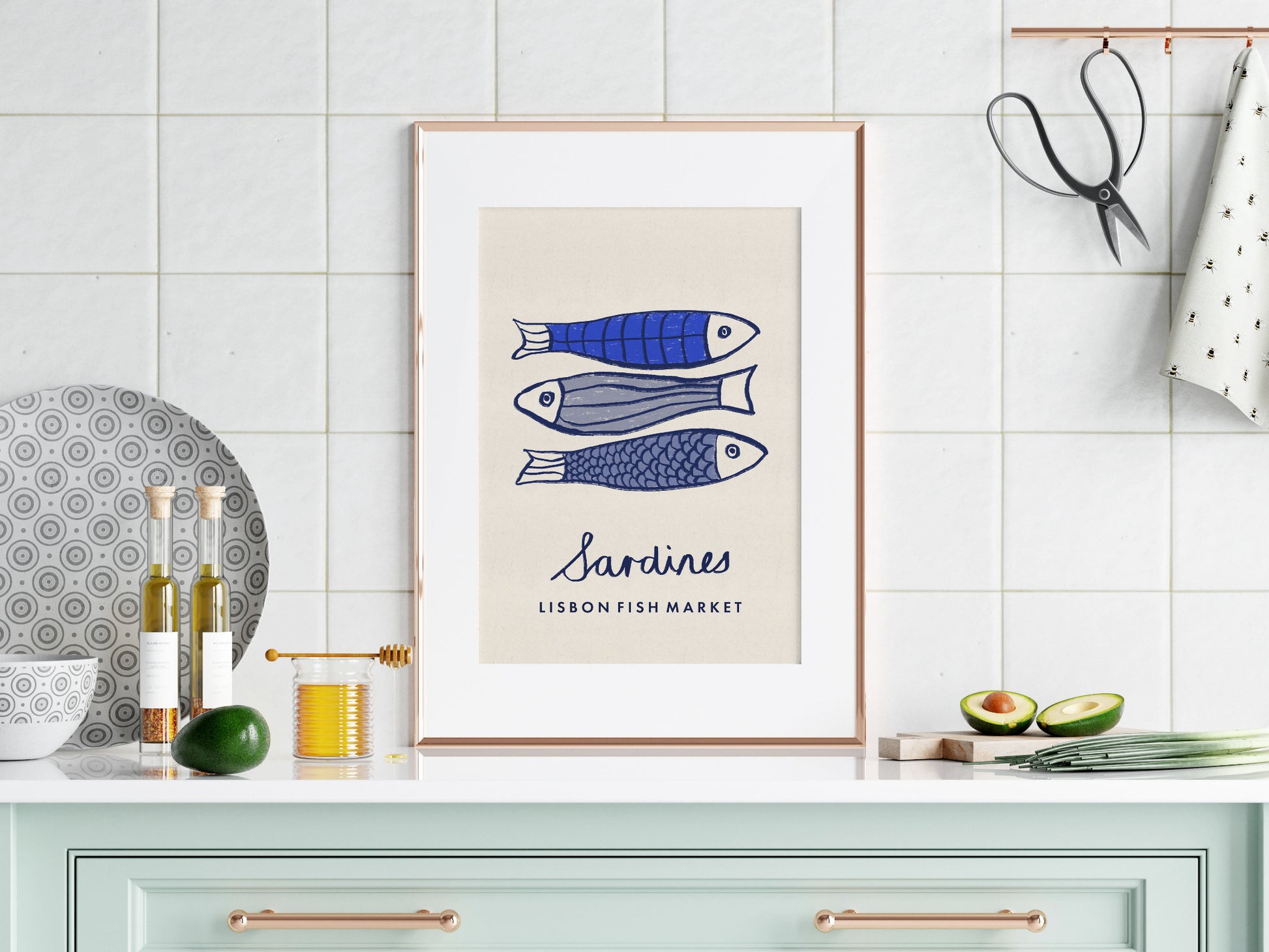 Framed artwork of sardines on a kitchen wall with decorative items.