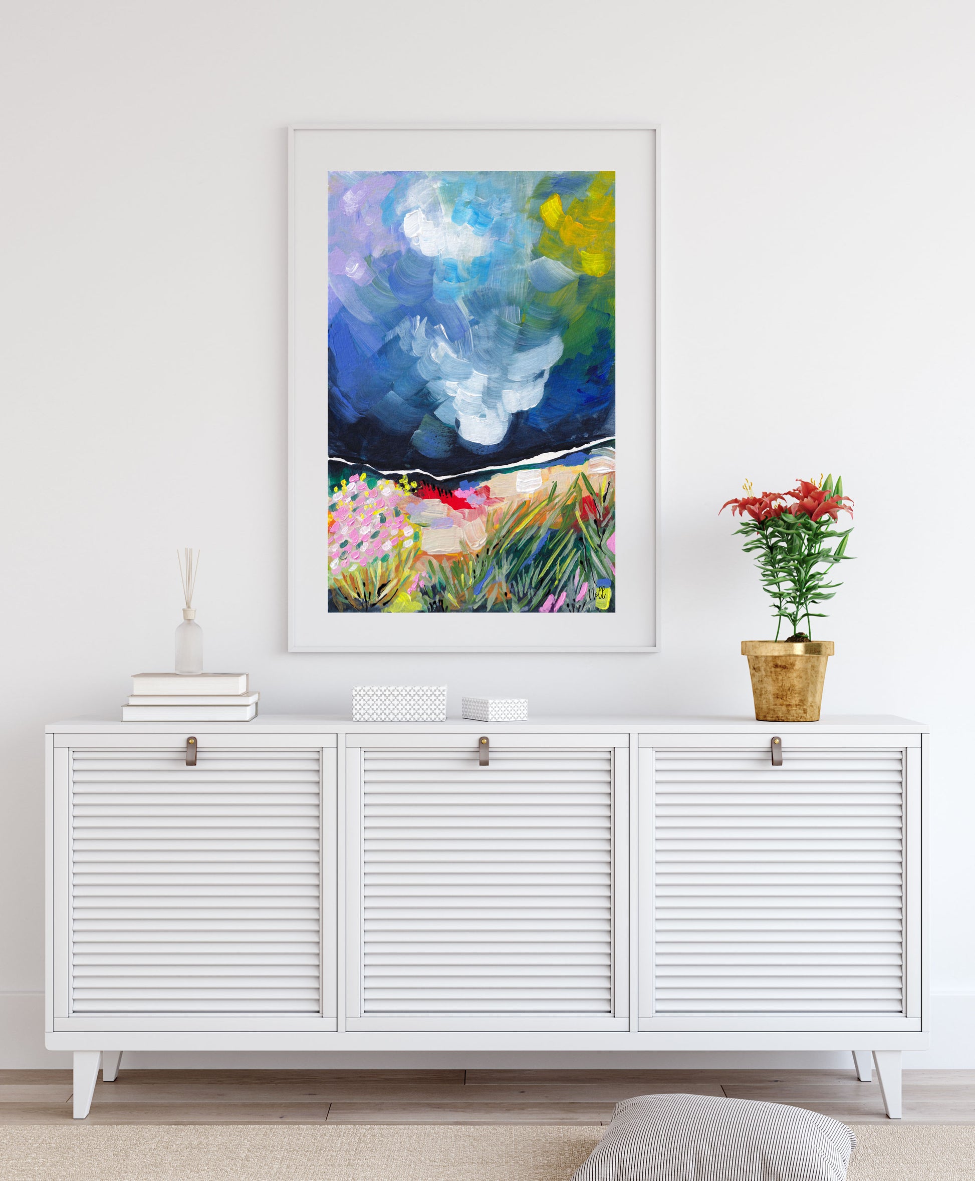 Colorful abstract painting on a white wall above a white cabinet.
