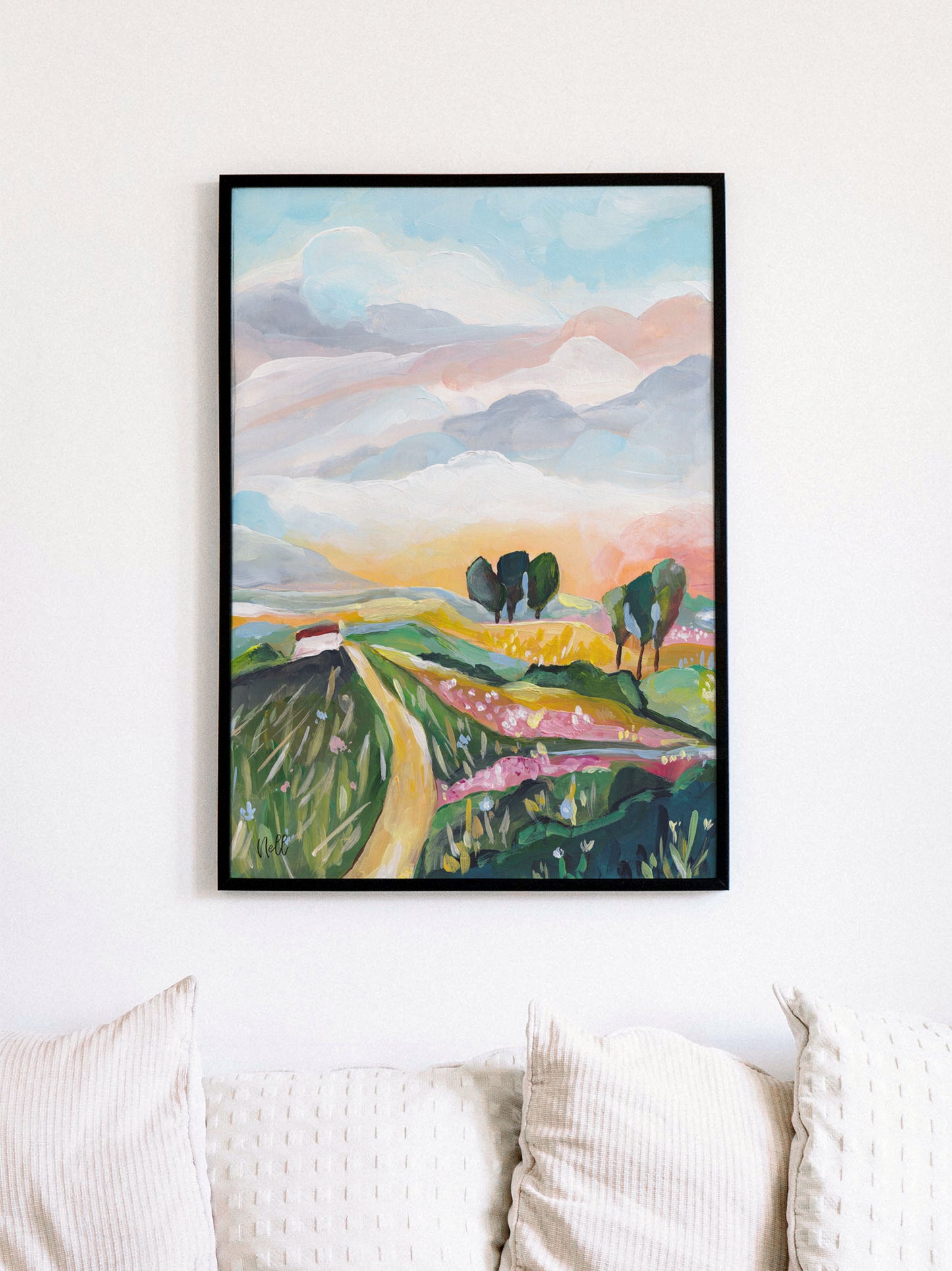 Framed abstract landscape painting on a wall above a sofa